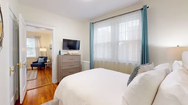 a bedroom with a bed and a flat tv screen on the dresser