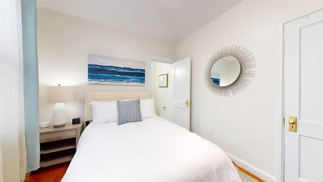 a bedroom with a bed and wooden floor