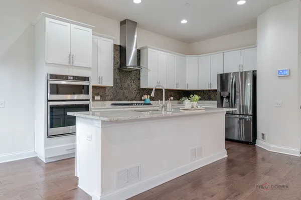 a kitchen with stainless steel appliances granite countertop a refrigerator a stove a sink and a microwave
