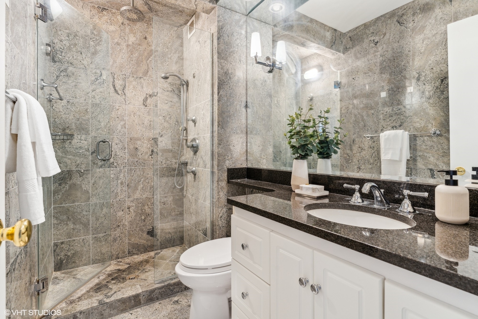 100 East Bellevue Place, Unit 18D Chicago, IL 60611 - Photo 16 of 24 a bathroom with a granite countertop sink a toilet a mirror and shower