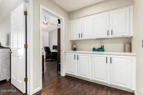 a kitchen with white cabinets and wooden floor