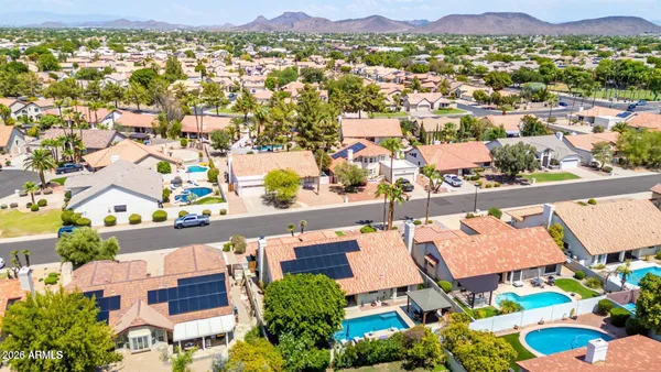 an aerial view of residential houses with outdoor space and parking