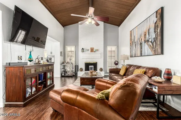 a living room with furniture a flat screen tv and a fireplace