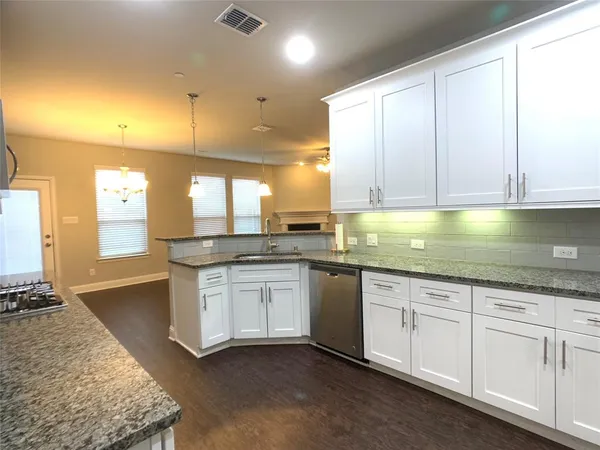 a kitchen with granite countertop a sink stainless steel appliances white cabinets and a granite counter tops