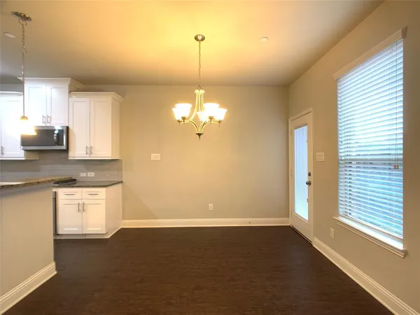 a kitchen with stainless steel appliances granite countertop a sink a stove a refrigerator a microwave oven with white cabinets