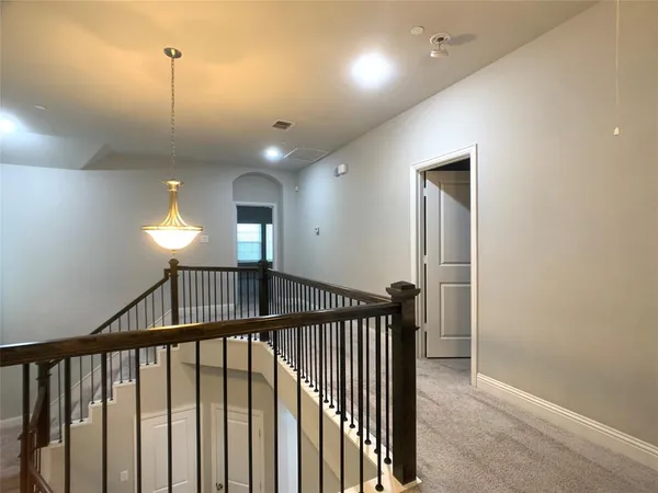 a view of staircase with railing and a chandelier