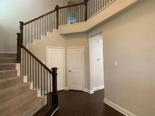a view of staircase with railing and white walls
