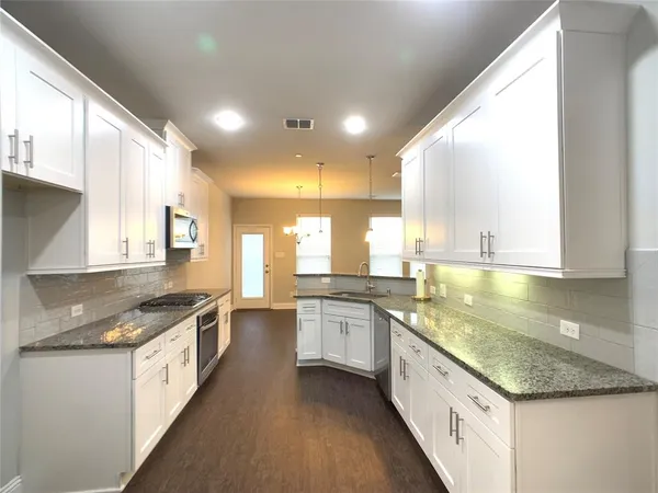 a large kitchen with stainless steel appliances granite countertop a lot of counter space
