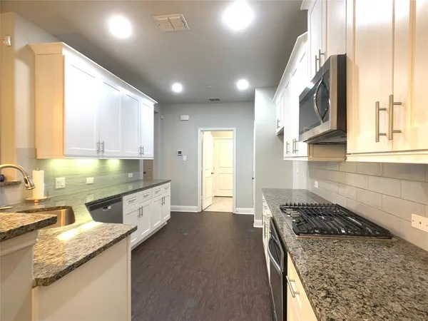 a kitchen with stainless steel appliances granite countertop a sink stove and cabinets