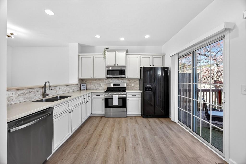 1646 Austin Meadows Drive Decatur, GA 30032 - Photo 13 of 29 a kitchen with a refrigerator a sink and dishwasher with wooden floor
