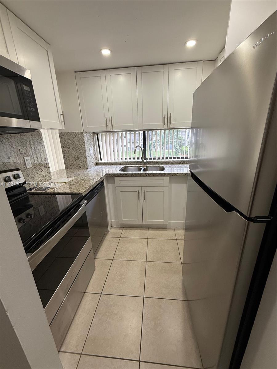 17011 North Bay Road, Unit 204 Sunny Isles Beach, FL 33160 - Photo 34 of 43 a kitchen with a sink stainless steel appliances and cabinets