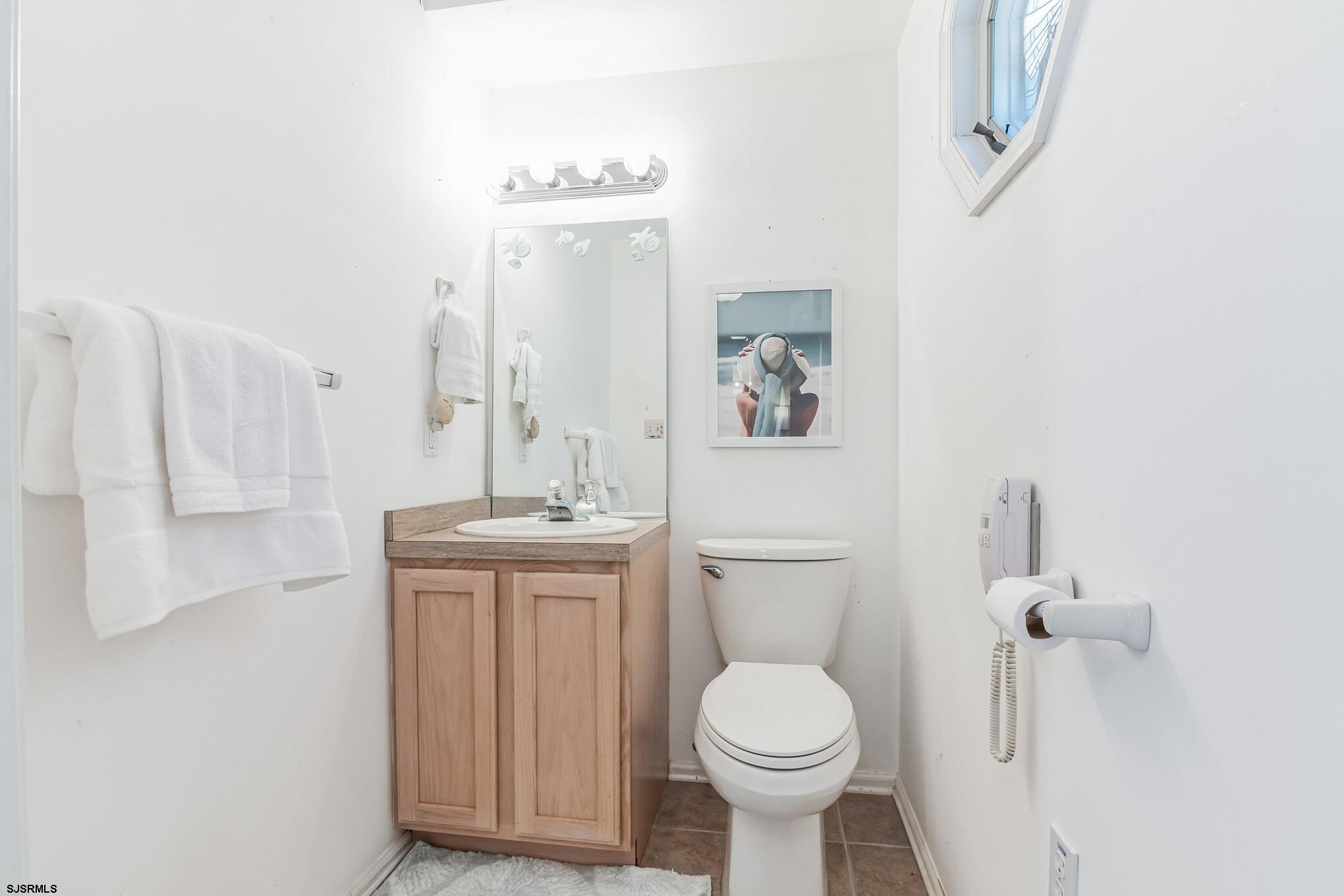 1 MacDonald Place Brigantine, NJ 08203 - Photo 14 of 36 a bathroom with a toilet sink and mirror