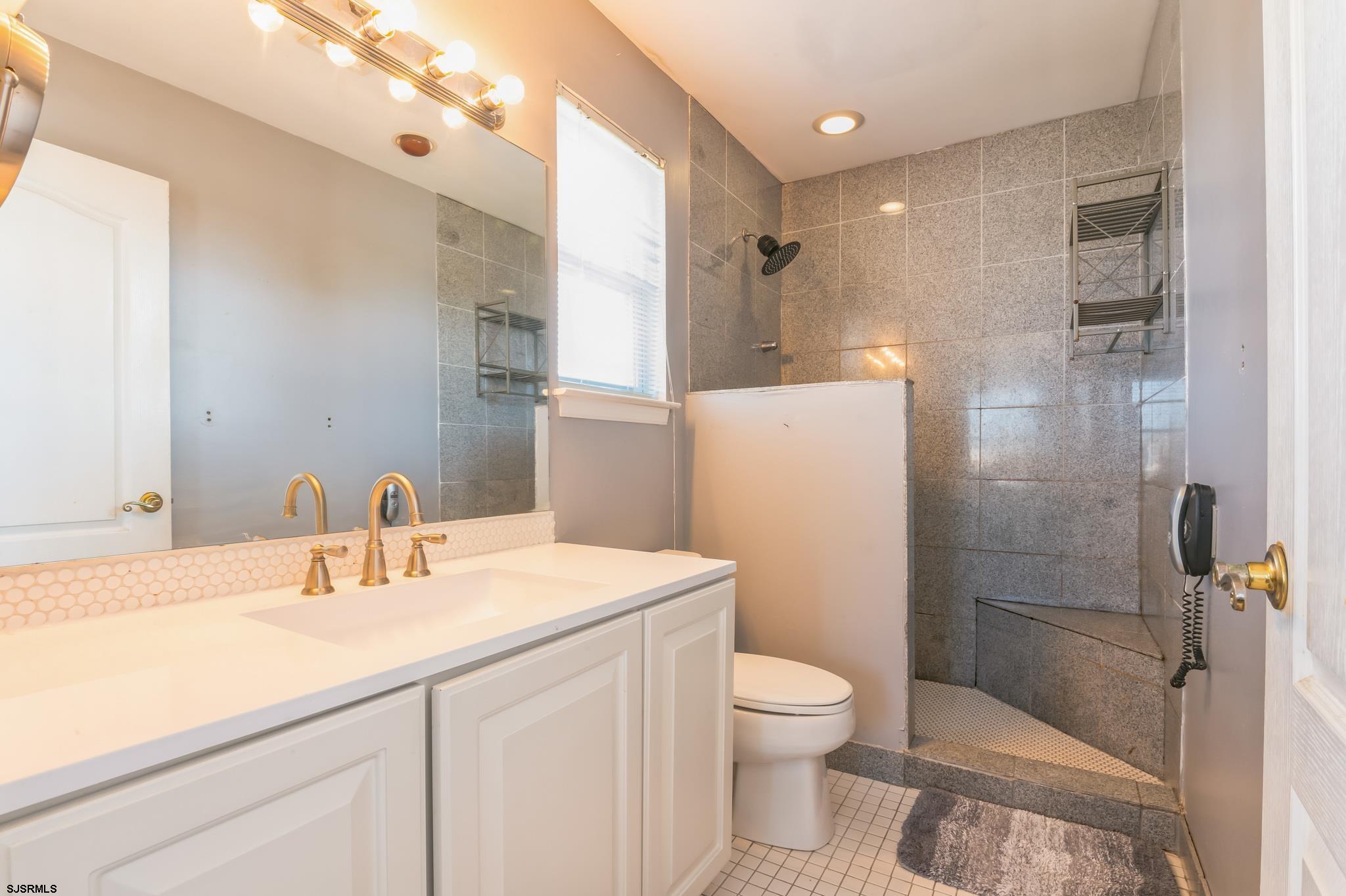 1 MacDonald Place Brigantine, NJ 08203 - Photo 17 of 36 a bathroom with a sink a toilet and shower