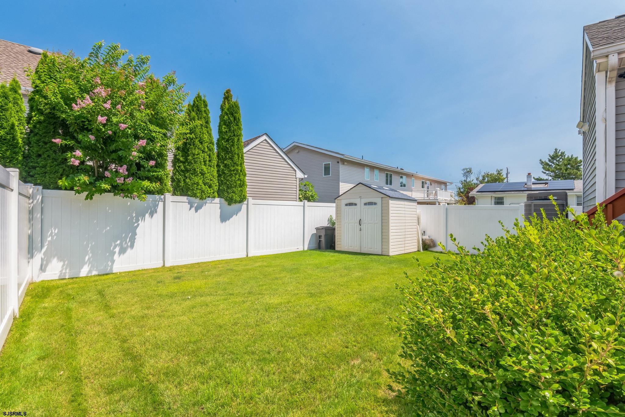 1 MacDonald Place Brigantine, NJ 08203 - Photo 27 of 36 a backyard of a house with plants and large tree