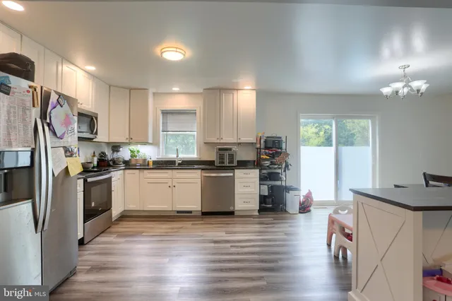 a kitchen with a refrigerator cabinets and wooden floor