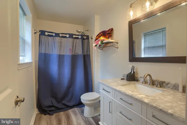 a bathroom with a granite countertop sink toilet and shower