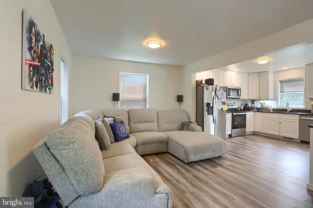 a living room with furniture and kitchen view