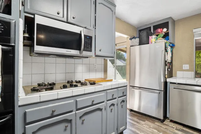 a kitchen with stainless steel appliances a refrigerator stove and microwave