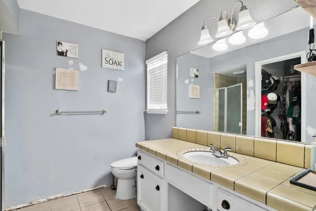 a bathroom with a granite countertop sink a toilet and mirror