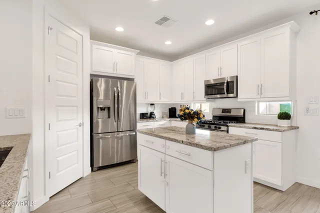 a kitchen with stainless steel appliances kitchen island granite countertop a sink and cabinets