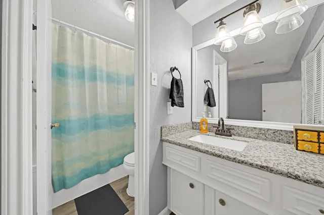 a bathroom with a granite countertop sink a mirror and a shower