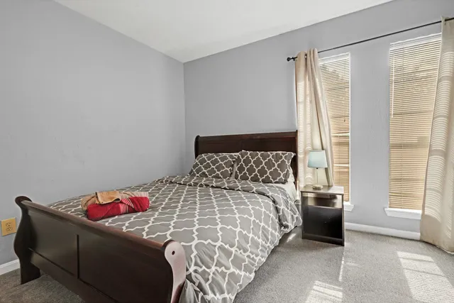 a bedroom with a bed and a window