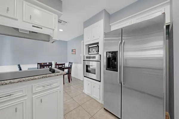 a kitchen with stainless steel appliances granite countertop a refrigerator and a sink