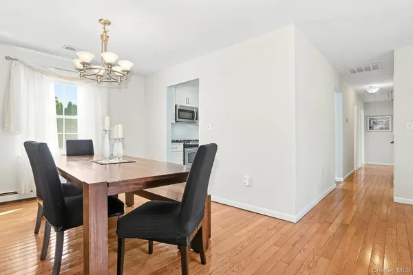 a view of a dining room with furniture a chandelier and wooden floor