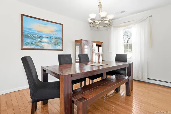 a view of a dining room with furniture a chandelier and wooden floor