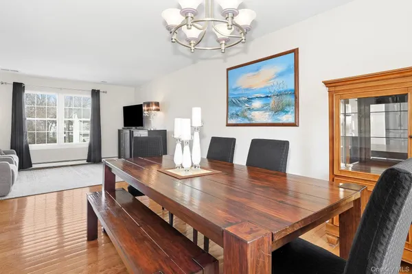 a view of a dining room with furniture a chandelier and wooden floor