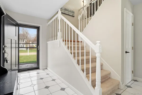 a view of staircase with white walls and next to a window