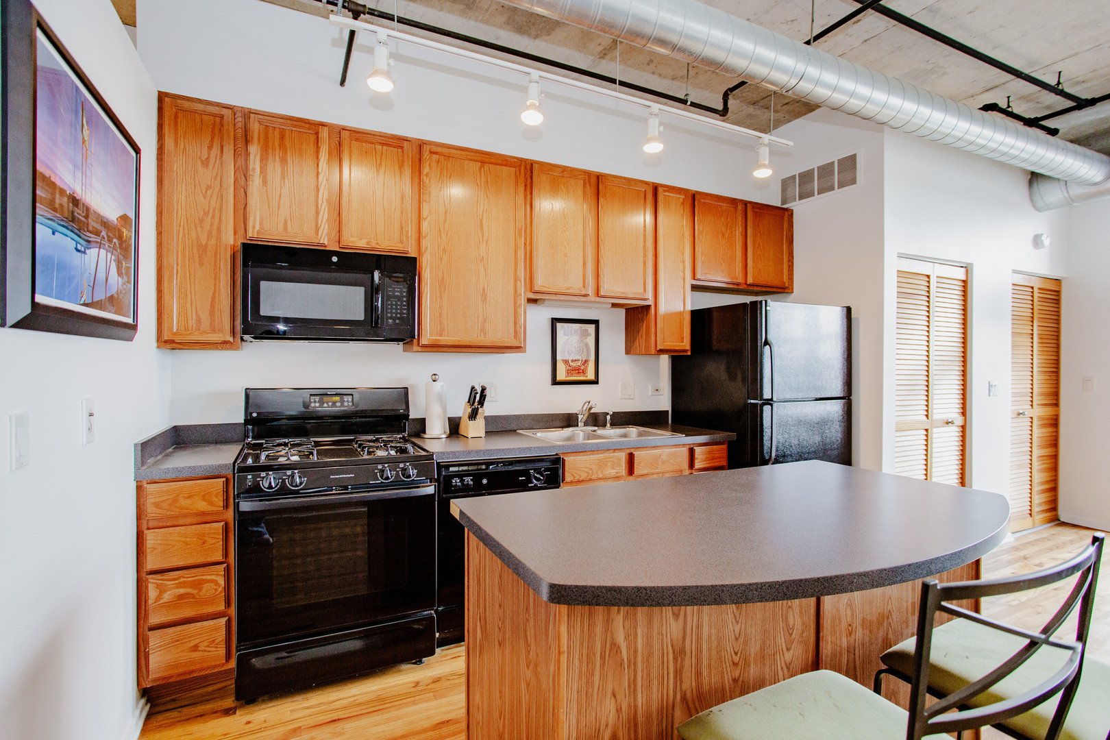 6 South Laflin Street, Unit 617 Chicago, IL 60607 - Photo 7 of 21 a kitchen with stainless steel appliances kitchen island granite countertop a stove a refrigerator a microwave oven with a dining table and chairs