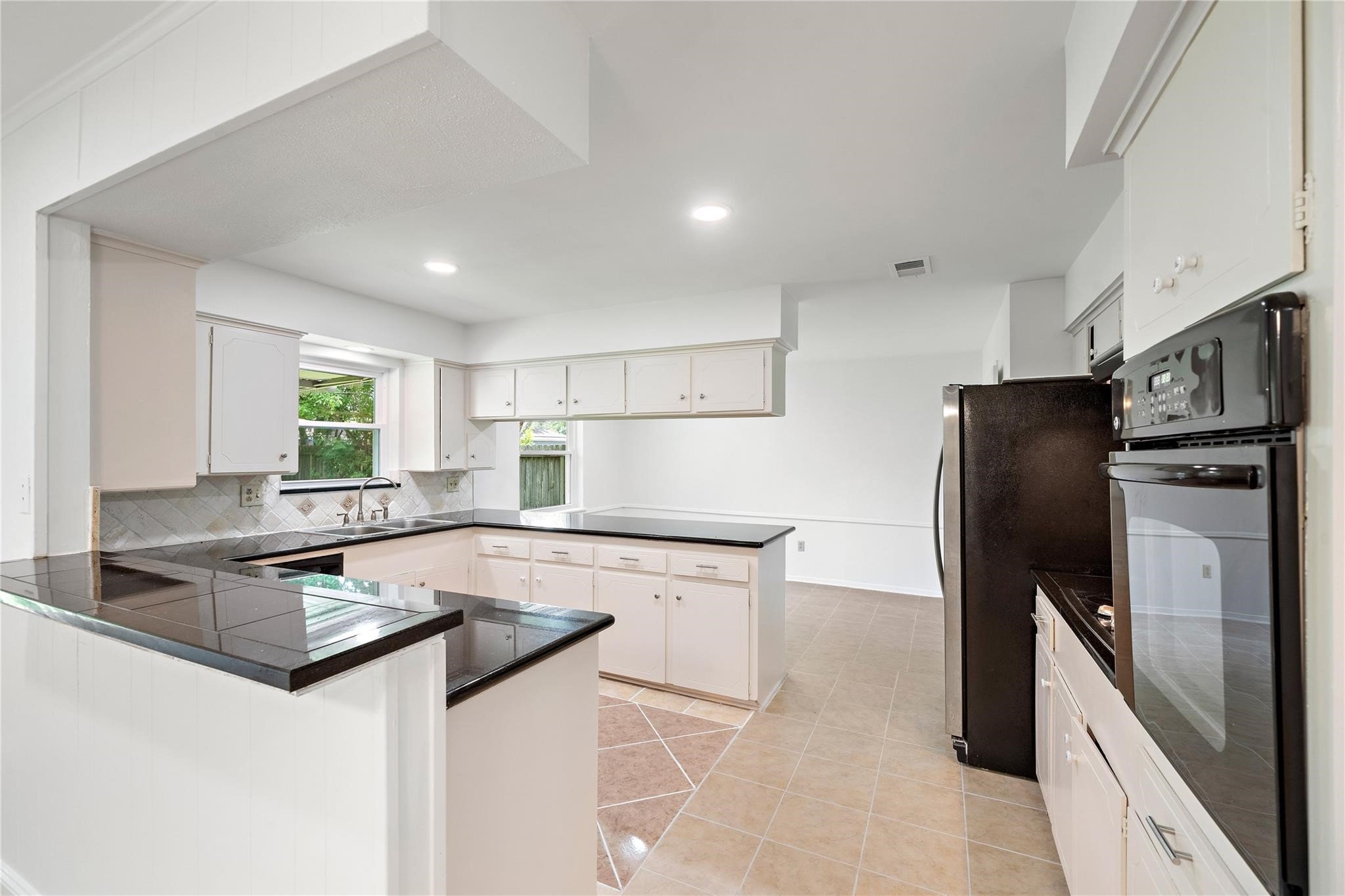 6007 Claridge Drive Houston, TX 77096 - Photo 32 of 38 a kitchen with granite countertop a refrigerator stove and sink