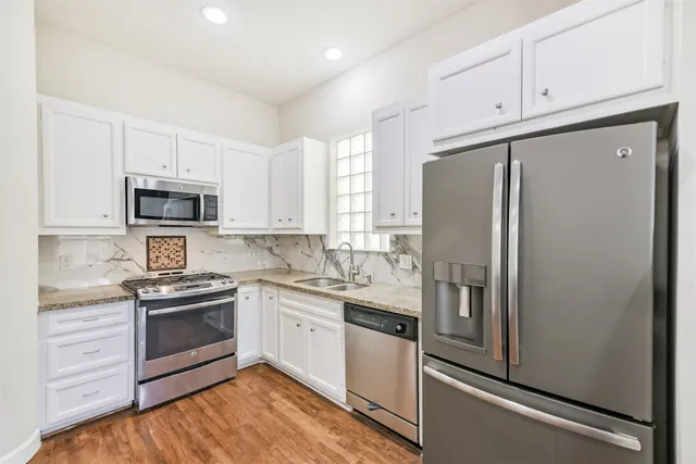 a kitchen with stainless steel appliances granite countertop a refrigerator stove and sink