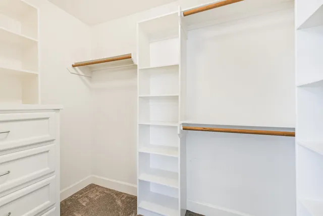 a view of walk in closet with empty racks