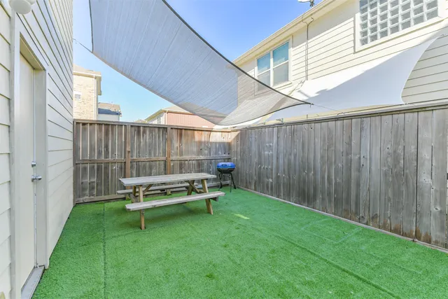 a backyard of a house with table and chairs