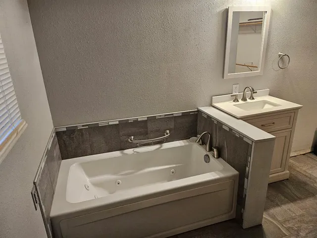 a bath tub sitting next to a white sink