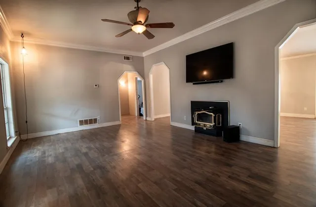 a view of a livingroom with a flat screen tv wooden floor and a ceiling fan