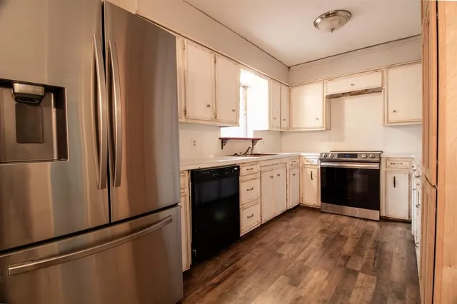 a kitchen with stainless steel appliances a refrigerator sink and white cabinets