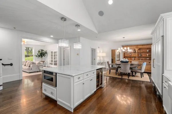 a living room with stainless steel appliances kitchen island granite countertop furniture a desk and chair with wooden floor