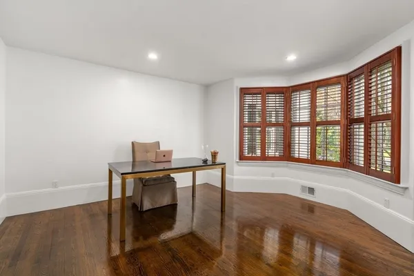 a view of a workspace with furniture and a window