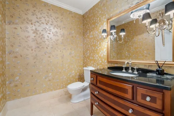 a bathroom with a granite countertop sink toilet and mirror