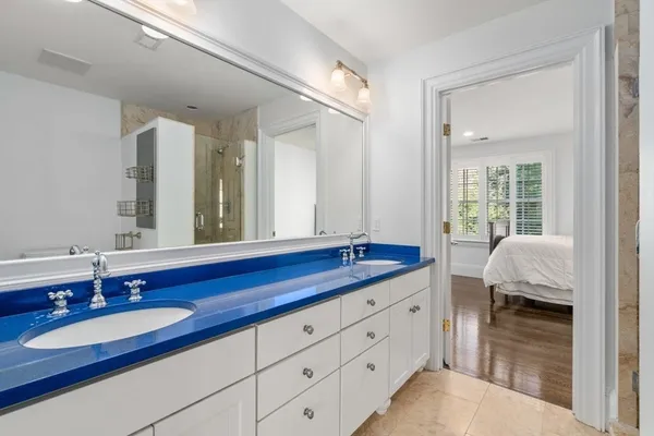 a en suite bathroom with a granite countertop double vanity sink and a mirror