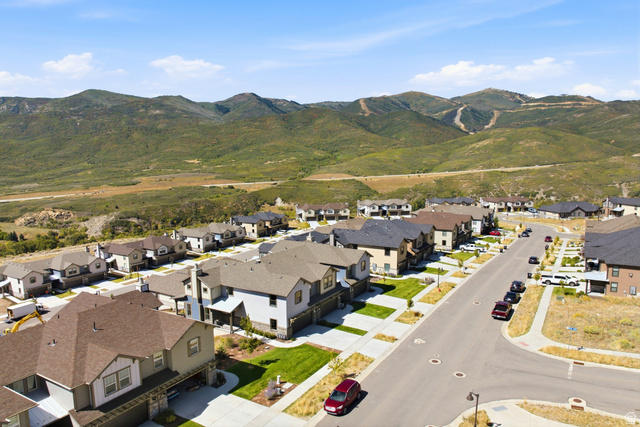 6039 North Westridge Road Heber City, UT 84032 - Photo 70 of 71 Residential neighborhood with paved streets and sidewalks, featuring multiple single-family homes with varying exterior finishes, against a backdrop of natural mountainous terrain