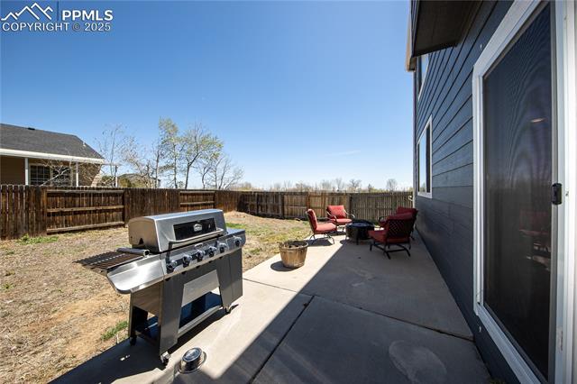 7511 Coffee Road Peyton, CO 80831 - Photo 36 of 38 View of patio / terrace featuring an outdoor fire pit, a fenced backyard, and a grill