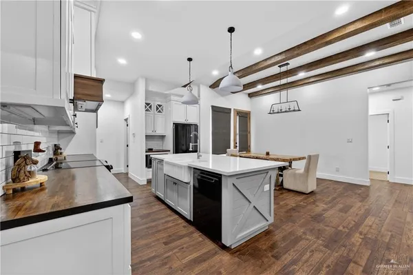 a kitchen with stainless steel appliances a sink stove and wooden floor
