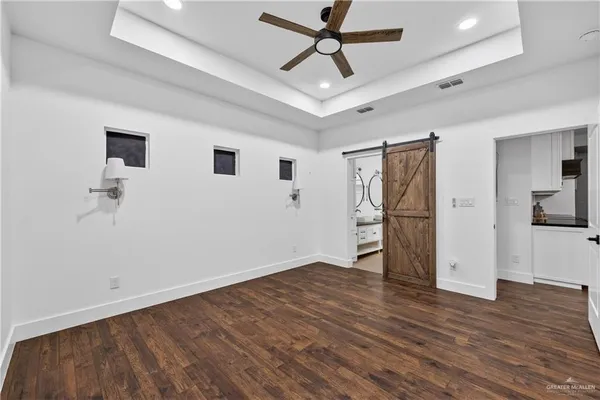 a view of empty room with wooden floor and ceiling fan