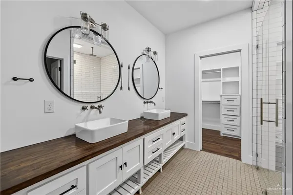 a bathroom with a granite countertop double vanity sink and a mirror