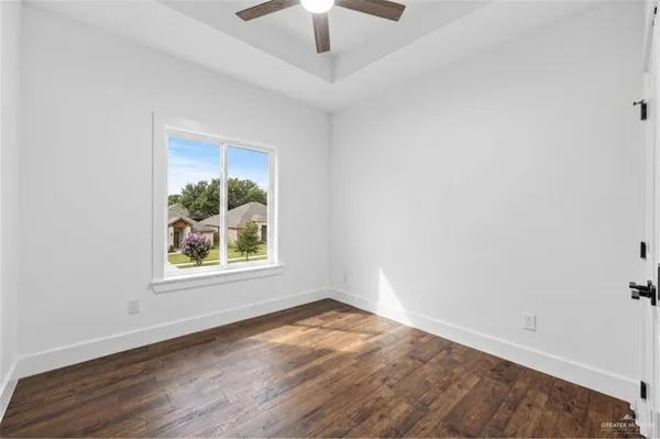 an empty room with a window and a ceiling fan
