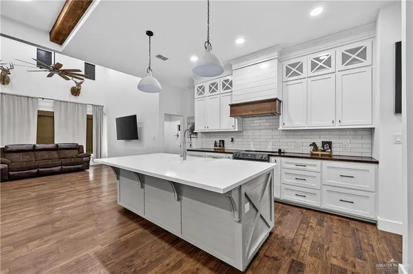 a kitchen with stainless steel appliances granite countertop a sink a stove and a refrigerator